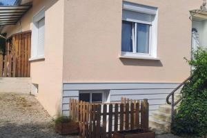 a house with a wooden fence and a window at Charmante petite maison in Torcenay