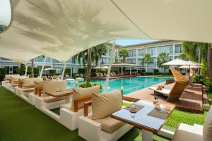 eine Hotelterrasse mit Tischen, Stühlen und einem Pool in der Unterkunft Lanna Samui in Bophut 