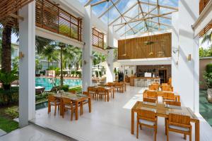 a restaurant with tables and chairs and a pool at Chi Samui Resort in Bophut