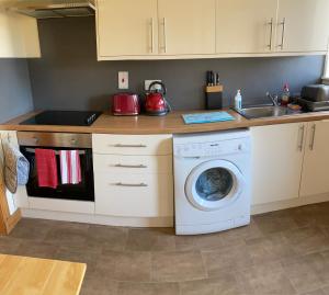a kitchen with a washing machine and a sink at Thurso Bay Holidays in Thurso