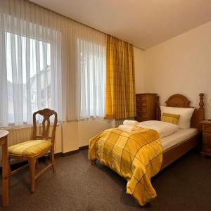 a bedroom with a bed and a chair and a window at Das Sigl's in Bad Schandau