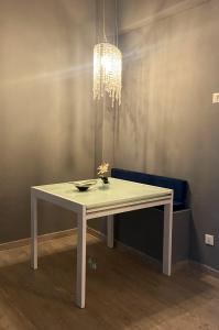 a white table with a bowl and a chandelier at Casa Rosmini rooms, Dolomia best home in Trento