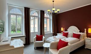 a bedroom with a white bed with red pillows at Das Sigl's in Bad Schandau