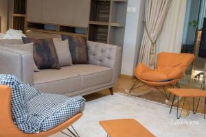 een woonkamer met een bank en stoelen bij Executive Suite Apartment in Cape Coast - Lakeview by Agnes in Cape Coast