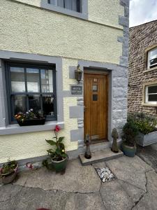 a front door of a house with potted plants at Cosy 2-Bed Cottage in Heysham Village Morecambe in Morecambe