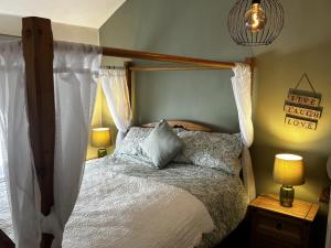 a bedroom with a canopy bed and two lamps at Cosy 2-Bed Cottage in Heysham Village Morecambe in Morecambe