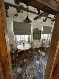 莫克姆的住宿－Cosy 2-Bed Cottage in Heysham Village Morecambe，一间带桌椅和狗的用餐室