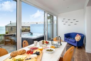 a dining room with a table with food on it at Hawkins Cottage with Hot Tub in Torpoint