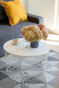 a white coffee table with flowers on top of it at Modern Apartment with Balcony by Noclegi Renters in Gdańsk