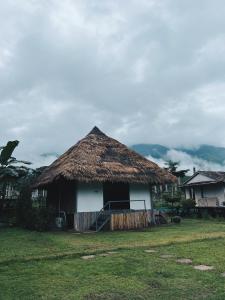 uma cabana com um telhado de relva num campo em สะปันดีวิว Sapan Dee View บ่อเกลือ น่าน em Ban Huai Ti