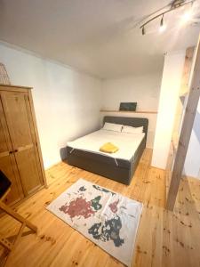 a small bedroom with a bed and a wooden floor at Weener - City Apartment mit Garten in Weener