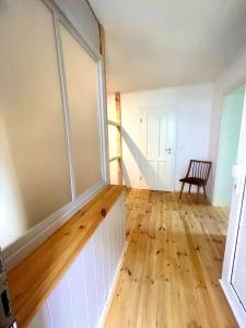 um quarto com uma grande janela e piso em madeira em Weener - City Apartment mit Garten em Weener