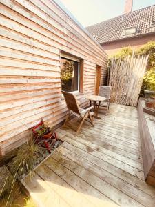 una terraza de madera con mesa y sillas. en Weener - City Apartment mit Garten en Weener