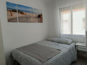 a bedroom with a bed and a picture of a beach at Ciudad Universitaria - Business Area Madrid - Moncloa in Madrid