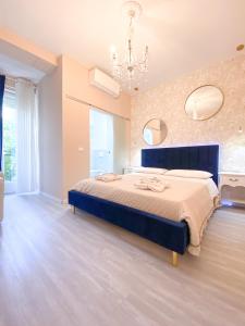 Habitación grande con cama azul y lámpara de araña. en Casa Rosmini rooms, Dolomia best home, en Trento