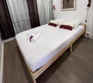 duże łóżko z białą pościelą i poduszkami w obiekcie Le Bayard YourHostHelper w Grenoble