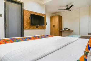 1 dormitorio con 1 cama y TV de pantalla plana en FabHotel Prime Shourya Residency, en Pune