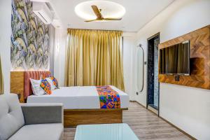a hotel room with a bed and a tv at FabHotel Prime Shourya Residency in Pune
