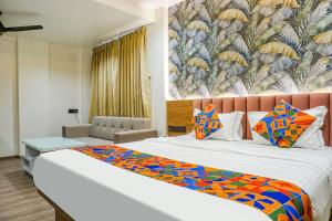1 dormitorio con 1 cama grande con una manta colorida en FabHotel Prime Shourya Residency, en Pune