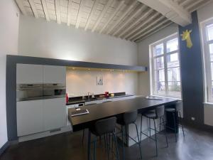 uma grande cozinha com um balcão preto e bancos em Au Beau Lieu de Metz em Lille