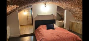 um quarto com uma cama e uma parede de tijolos em Au Beau Lieu de Metz em Lille