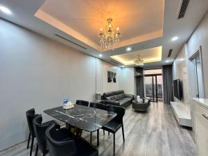 een woonkamer met een eettafel en een bank bij Paradise Home Royal City in Hanoi