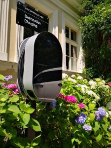 a black and white object in a garden of flowers at Dwór Sieraków in Sieraków