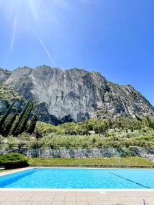 una piscina con una montaña en el fondo en Appartamento Panorama, en Riva del Garda