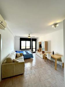 Appartamento Panorama في ريفا ديل غاردا: غرفة نوم مع أريكة وسرير وطاولة