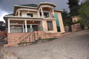 une maison avec une allée en briques devant elle dans l'établissement Vincenzo trading, à Kigali