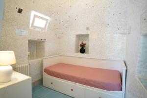 een kleine slaapkamer met een bed in een kamer bij trullo lantane in San Michele Salentino