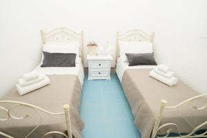 twee bedden naast elkaar in een slaapkamer bij trullo lantane in San Michele Salentino