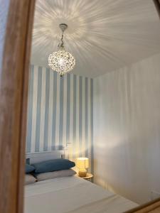 um quarto com uma cama e um lustre em Il Faro beach house em Marina di Pisa