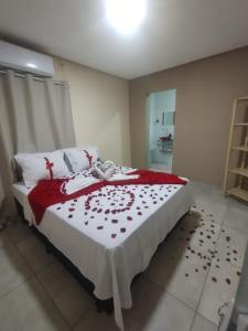 um quarto com uma cama com um cobertor vermelho e branco em Pousada Vista da Serra - Suzart em Lençóis