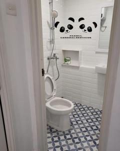 a bathroom with a toilet and a blue and white floor at Apartment Kalibata City by PanBul in Jakarta