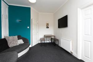 sala de estar con sofá y TV de pantalla plana en Saltwell Oasis: 5-Bed Delight en Low Team