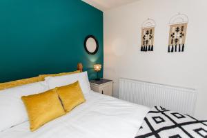 a bedroom with a white bed and a green wall at Saltwell Oasis: 5-Bed Delight in Low Team