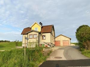 uma grande casa amarela com uma garagem numa estrada em Holiday apartment in Vessigebro em Vessigebro