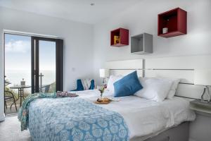 a bedroom with a bed with a view of the ocean at Sandpiper in Torpoint