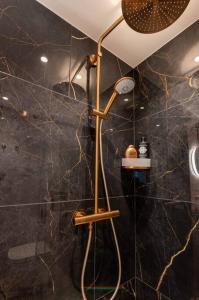 a bathroom with a shower with black marble walls at Appartement met frontaal zeezicht in Koksijde