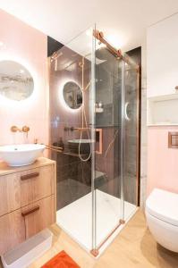 a bathroom with a glass shower and a sink at Appartement met frontaal zeezicht in Koksijde
