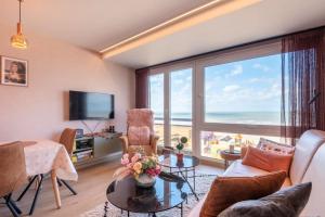 a living room with a view of the ocean at Appartement met frontaal zeezicht in Koksijde