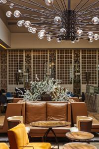 - un hall avec un canapé et une grande composition florale dans l'établissement Lady Stern Jerusalem Hotel, à Jérusalem