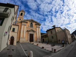 a church with a clock tower on a street at Nz Home in Foligno