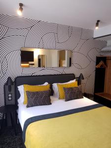 a bedroom with a large bed with yellow and black pillows at Hotel Vacances Bleues Villa Modigliani in Paris