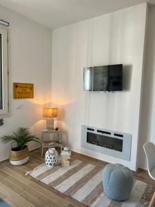 een woonkamer met een tv aan een witte muur bij Il Faro beach house in Marina di Pisa