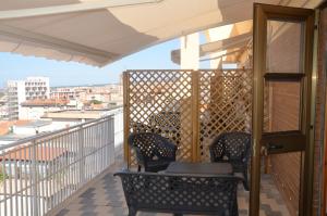 balcón con 2 sillas y vistas a la ciudad en RESIDENZA LE TERRAZZE SASSARI CASA G PISCHEDDA bY FANTASTIC SARDINIA, en Sassari