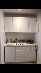a white kitchen with white cabinets and a sink at Sunny Garden. YBG. 1 Bedroom Apt. Quiet in Tel Aviv