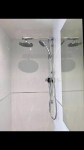 uma casa de banho com um chuveiro numa parede branca em Sunny Garden. YBG. 1 Bedroom Apt. Quiet em Tel Aviv