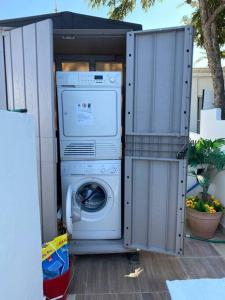 uma máquina de lavar e secar roupa num barracão de metal em Sunny Garden. YBG. 1 Bedroom Apt. Quiet em Tel Aviv
